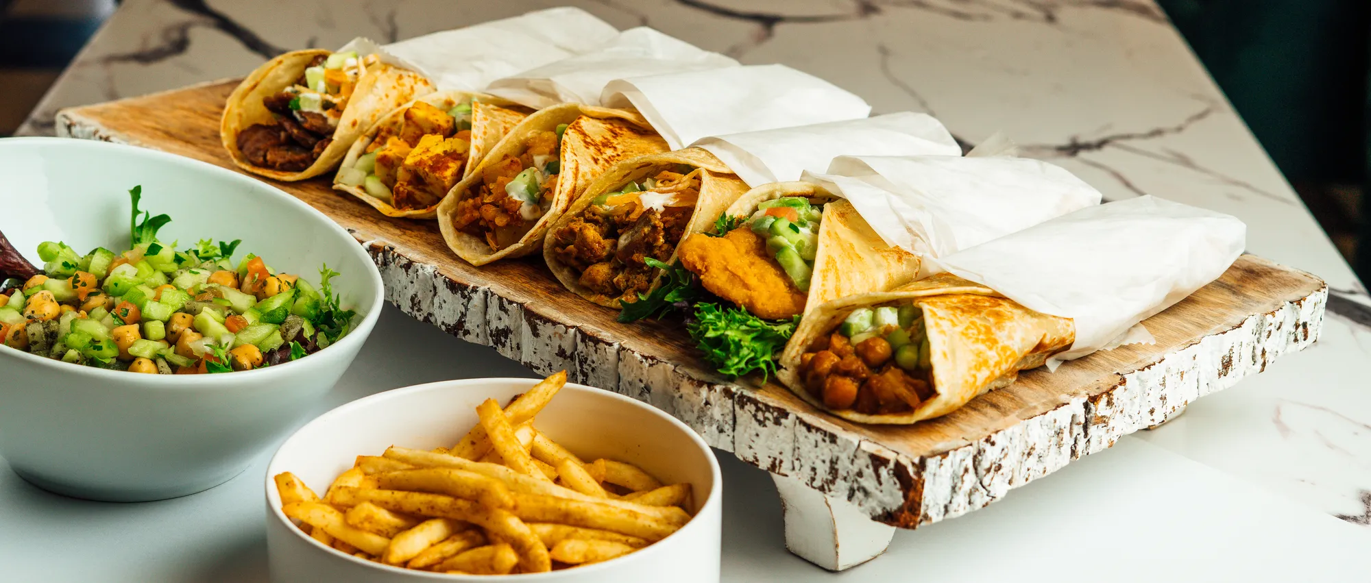 A party spread of Hinzi's kati roll platters, salad and fries