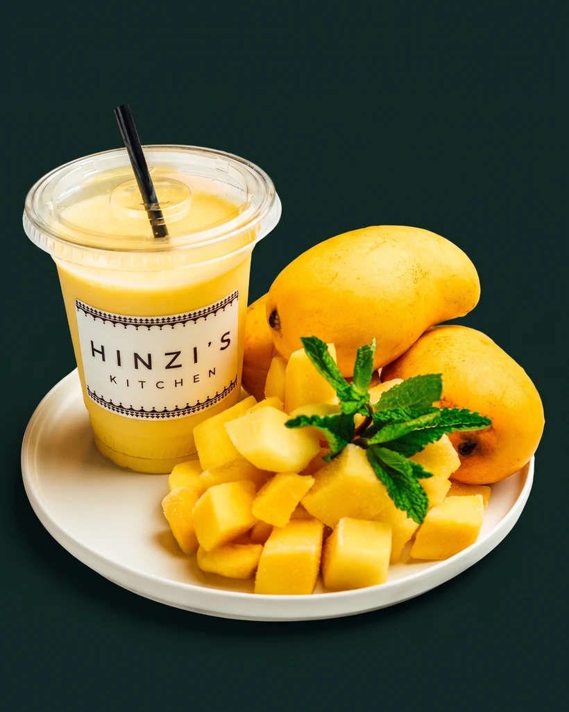 Hinzi's mango lassi with fresh mango and mint, studio-shot on emerald