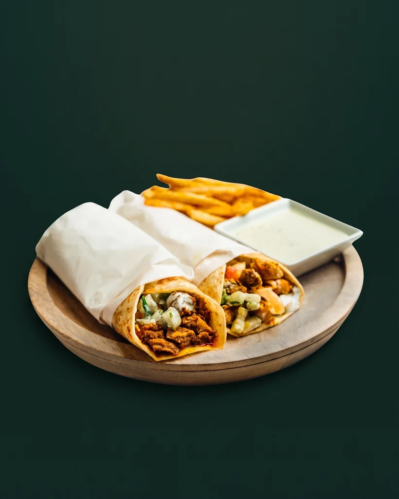 Hinzi's chicken kati rolls in flaky paratha with fries and dip, studio-shot on emerald