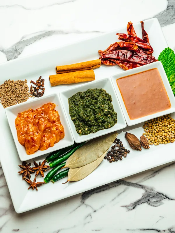 Hand-crafted sauces with whole spices on marble